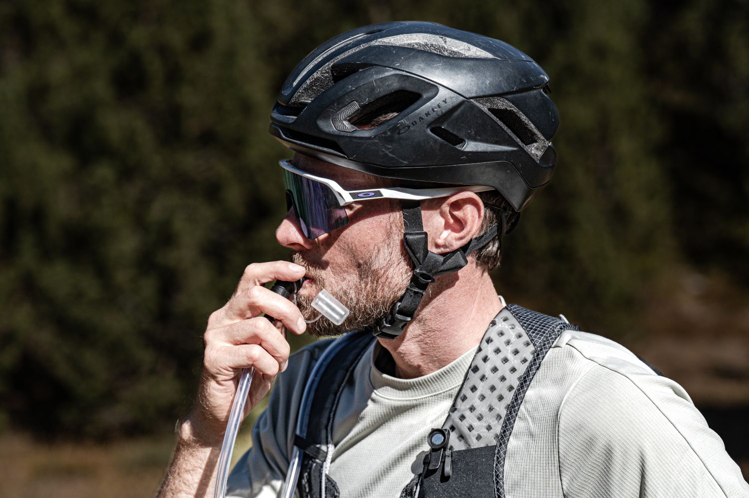 Ultracyclist trinkt während einer langen Radtour aus einer Hydration Vest